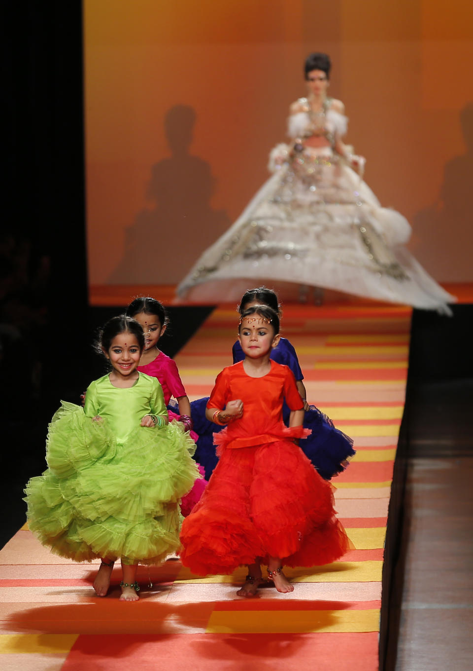 Children run ahead of a model wearing the weeding gown for French fashion fashion designer Jean-Paul Gaultier's Spring-Summer 2013 Haute Couture fashion collection, presented in Paris, Wednesday, Jan.23, 2013. (AP Photo/Jacques Brinon)