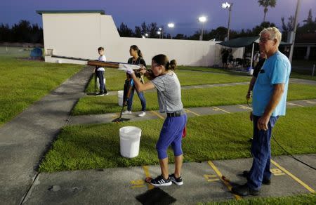 Viera Rybak, 12, shoots as instructor Steve Norris looks on during a clay target youth group shooting meeting in Sunrise, Florida, U.S., February 26, 2018. Picture taken February 26, 2018. REUTERS/Joe Skipper