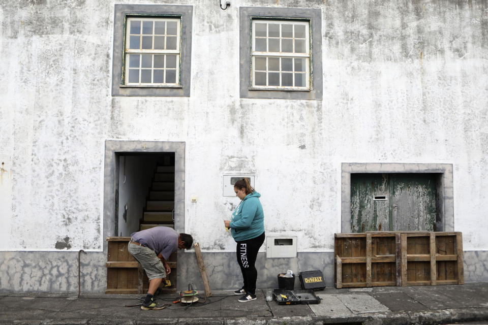 Residents board up a door in preparation for the arrival of hurricane Lorenzo in Horta, the capital of the Portuguese island of Faial, Tuesday, Oct. 1, 2019. The Category 2 hurricane is expected to hit the Atlantic Ocean Portuguese archipelago of the Azores Tuesday night and Wednesday morning. Lorenzo was previously a Category 5 hurricane, the strongest storm ever observed so far north and east in the Atlantic basin. (AP Photo/Joao Henriques)