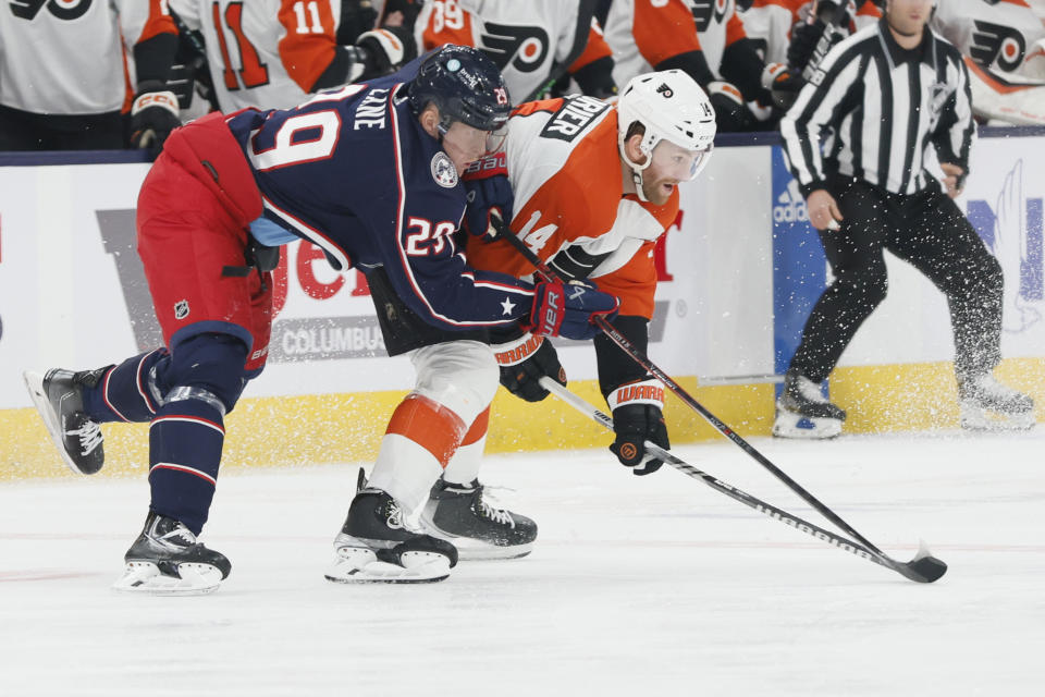 Columbus Blue Jackets' Patrik Laine, left, and Philadelphia Flyers' Sean Couturier chase the puck during the first period of an NHL hockey game Thursday, Oct. 12, 2023, in Columbus, Ohio. (AP Photo/Jay LaPrete)