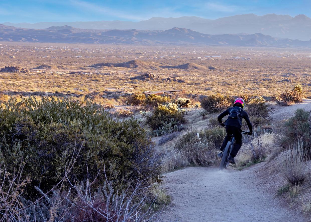 A guy riding a mountain bike down Toms Thumb Trail in Scottsdale.