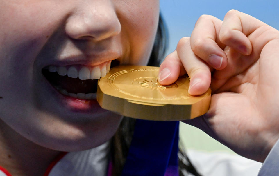 <strong>張雨霏在女子200米蝶泳決賽頒獎儀式後咬金牌。（圖／新華社）</strong>