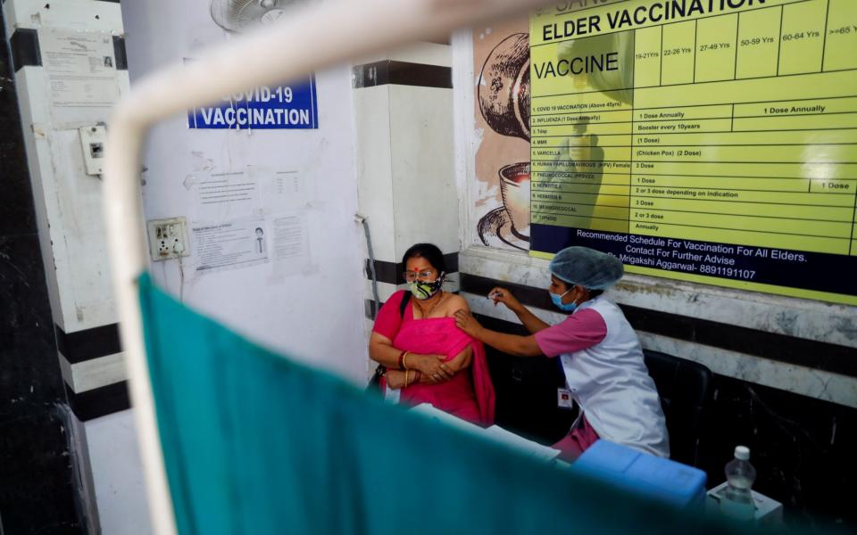 A woman is vaccinated at a centre in New Delhi, India - REUTERS/Adnan Abidi