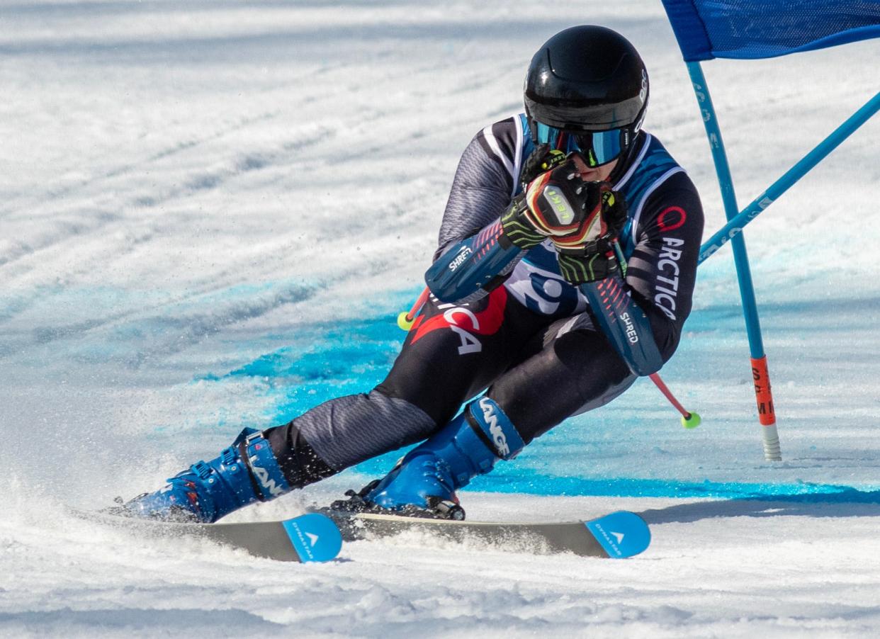 Mihai Gavala of St. John's tucks past a gate during a run Tuesday at the  MIAA Alpine Ski Championships at Wachusett Mountain.