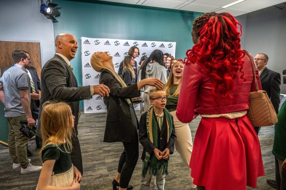 Sacramento State’s new women’s basketball head coach Aaron Kallhoff, left, wife Josie, and daughter Camden, 15, react Wednesday after Isnelle Natabou, a member of year’s team, right, shows off a funny T-shirt, while his other children, Capri, 7, and Caylix, 10, look on after Kallhoff’s first press conference on campus.