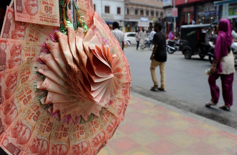 A stall at a market in Srinagar on August 28, 2013 sells wedding garlands made from Indian rupee notes