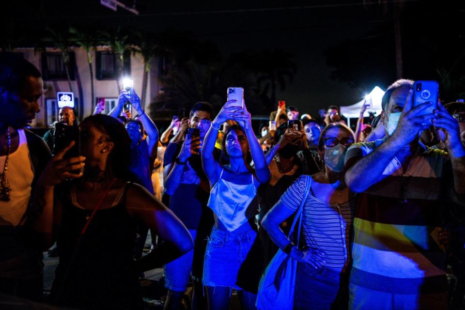 People watch as the rest of the Champlain South tower is demolished by a controlled explosion in Surfside, Florida.