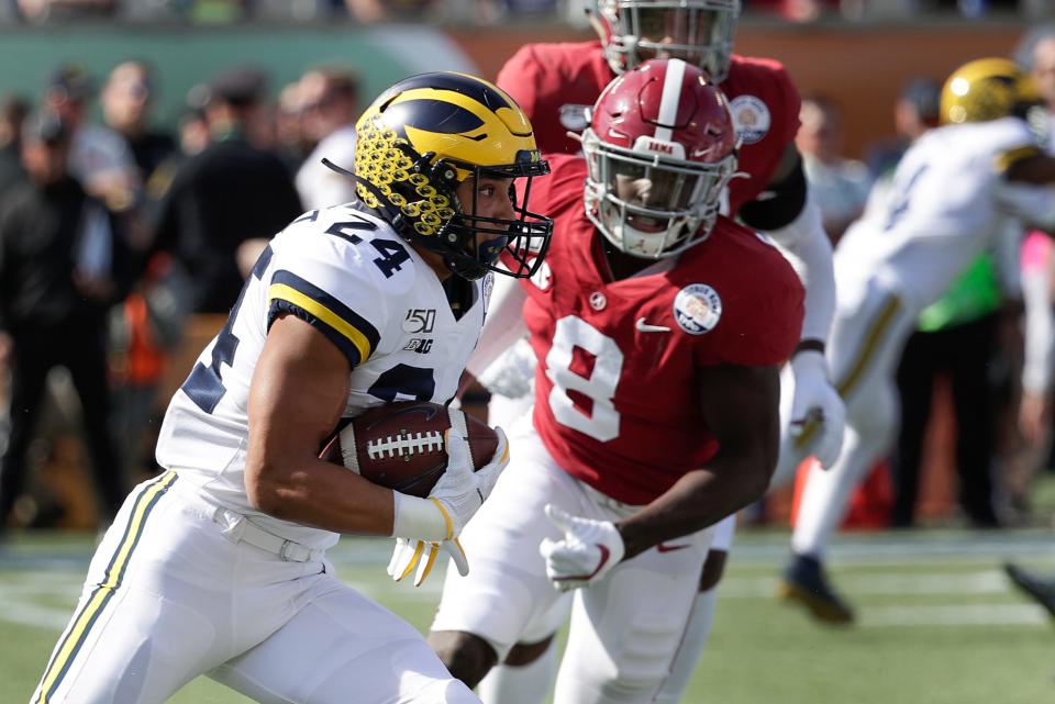 Michigan's Zach Charbonnet runs for yardage past Alabama linebacker Christian Harris during the first half of the Citrus Bowl, Jan. 1, 2020, in Orlando, Fla.