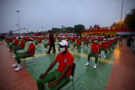 People wearing face masks and dressed in the colors of the national flag wait for the start of the Independence Day ceremony on the ramparts of the landmark Red fort monument in New Delhi, India, Saturday, Aug. 15, 2020. India’s coronavirus death toll overtook Britain's to become the fourth-highest in the world with another single-day record increase in cases Friday. (AP Photo/Manish Swarup)