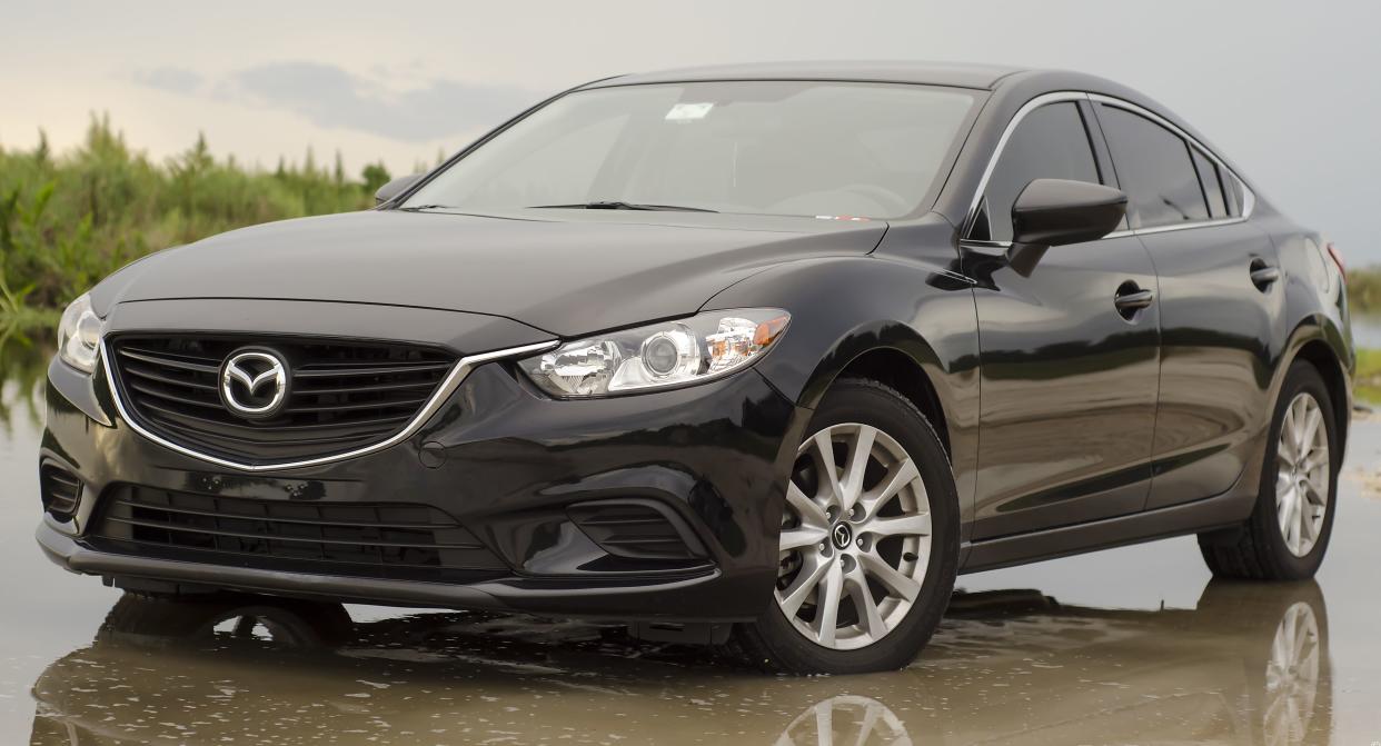 Black 2014 Mazda6 parked outside on a wet parking lot