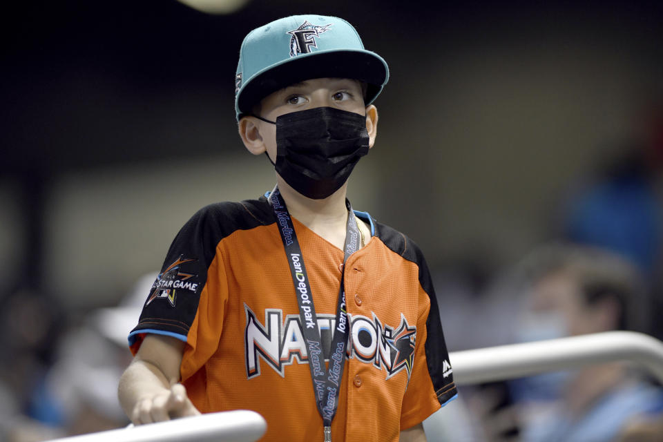A young Miami Marlins fan watches during the seventh inning of the Marlins' baseball game against the Tampa Bay Rays, Thursday, April 1, 2021, in Miami. The Rays won 1-0. (AP Photo/Gaston De Cardenas)