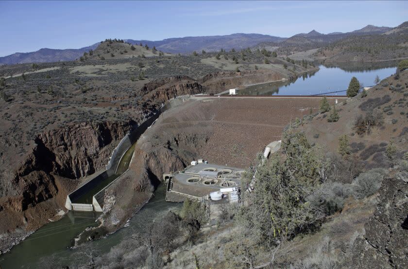 FILE - In this March 3, 2020, file photo, is the Iron Gate Dam, powerhouse and spillway are on the lower Klamath River near Hornbrook, Calif. A new agreement announced Tuesday, Nov. 17, 2020, promises to revive faltering plans to demolish four massive hydroelectric dams on a river along the Oregon-California border to save imperiled salmon by emptying giant reservoirs and reopening hundreds of miles of potential fish habitat that's been blocked for more than a century. (AP Photo/Gillian Flaccus, File)