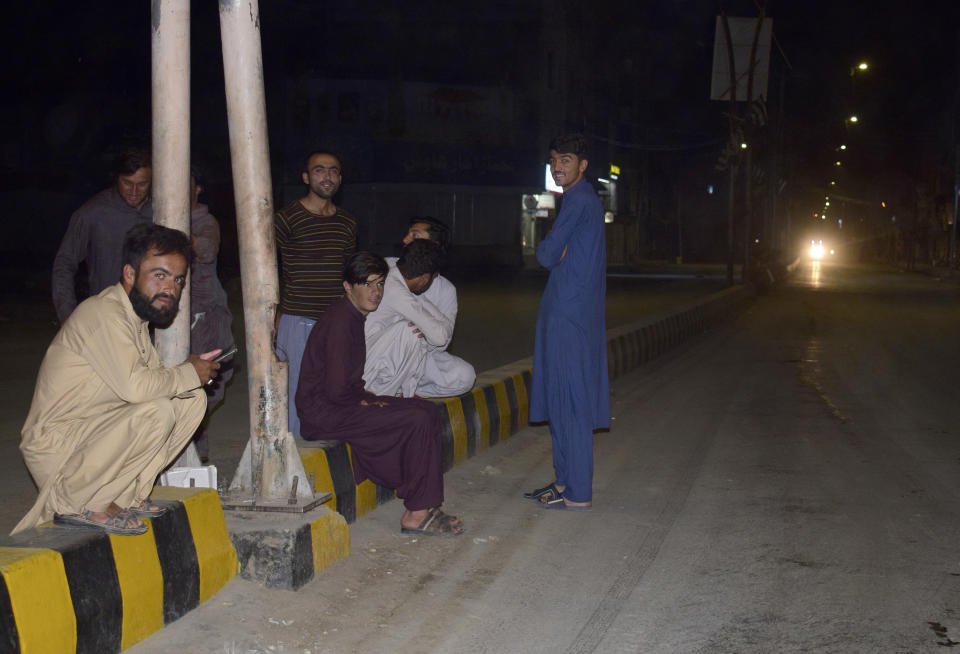 Local residents gather outside their houses following a severe earthquake is felt the area, in Quetta, Pakistan, Thursday, Oct. 7, 2021. A powerful earthquake collapsed at least one coal mine and dozens of mud houses in southwest Pakistan early Thursday. (AP Photo/Arshad Butt)