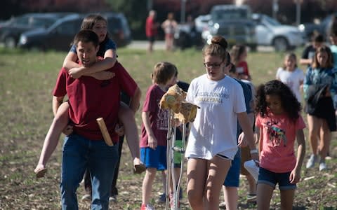 Evacuated students and staff march to buses to be carried offsite outside Noblesville West Middle School  - Credit: Getty