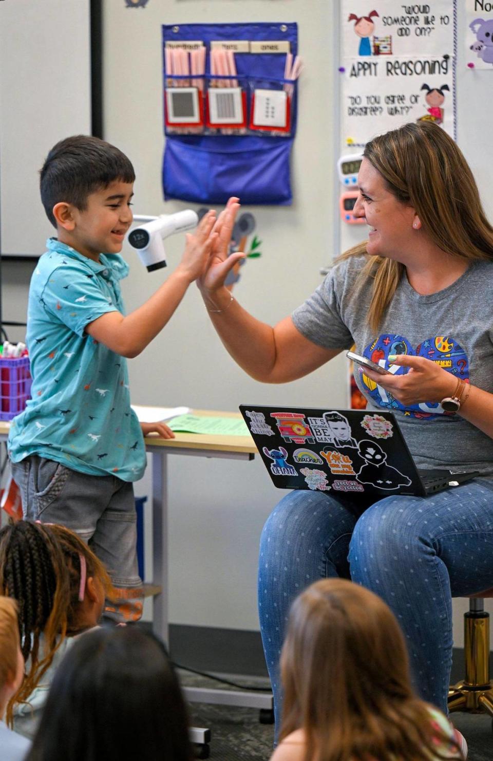 Abu Saidov, a first grader, high-fives teacher Mary Krejci, after she used Google Translate to translate a word from English to Russian so Abu could understand her question on May 10, 2023, at Piper Prairie Elementary School in Kansas City, Kansas. Krejci was announced as the winner of the Kansas City Star’s Honor Roll teacher poll.