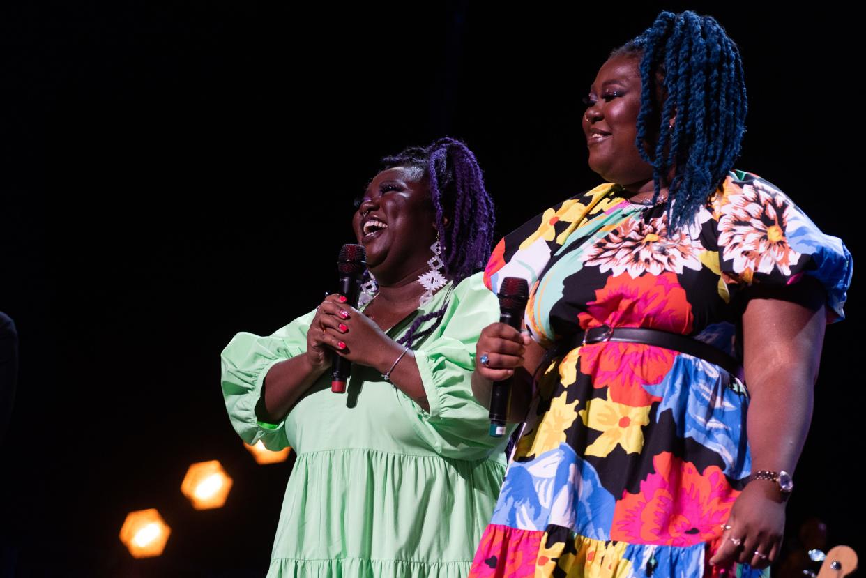 Chauntee (left) and Monique Ross take in the applause from their hometown crowd at Fiserv Forum in Milwaukee on Aug. 5. The sisters, who made waves in the local music scene with their duo SistaStrings, performed as part of Brandi Carlile's band at the Bucks arena. They'll perform on "Saturday Night Live" on Dec. 10.