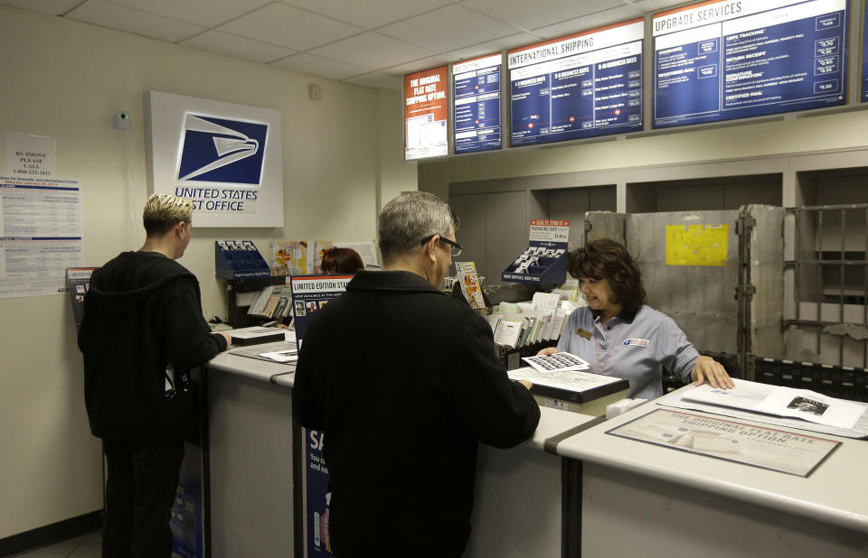 Ren Sanz, left, and Mark Simon buy books of commemorative stamps honoring Harvey Milk, the California politician and gay rights icon, at a U.S. Post Office in San Francisco, Thursday, May 22, 2014. The stamps were released today. (AP Photo/Jeff Chiu)