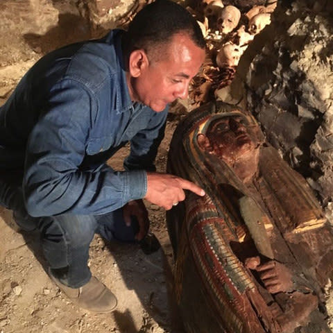 An Egyptian archaeologist looks at a newly-uncovered sarcophagus in the Draa Abul Naga necropolis - Credit: Egyptian Ministry of Antiquities via AFP 