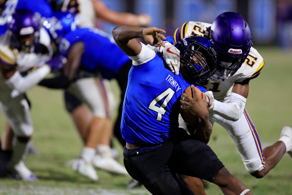 Columbia's Jerome Carter (21) tackles Trinity Christian Academy's Darnell Rogers (4) during the third quarter of a regular season football game Friday, Sept. 23, 2022 at Trinity Christian Academy in Jacksonville. Trinity Christian Academy defeated the Columbia Tigers 43-30.  