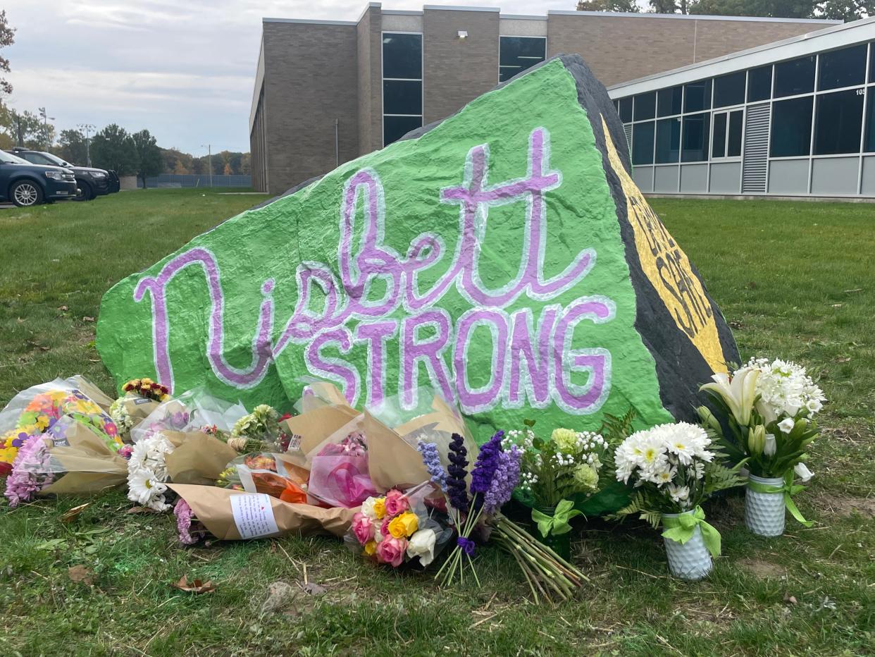 A rock in front of Port Huron Northern painted to read 'Nisbett Strong' with flowers around it on Oct. 25, 2023.