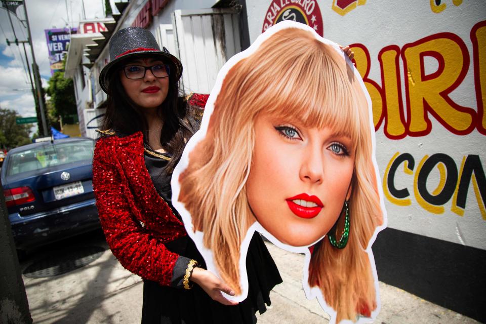 A fan holds a poster of Taylor Swift's face in Mexico City on Aug. 24.
