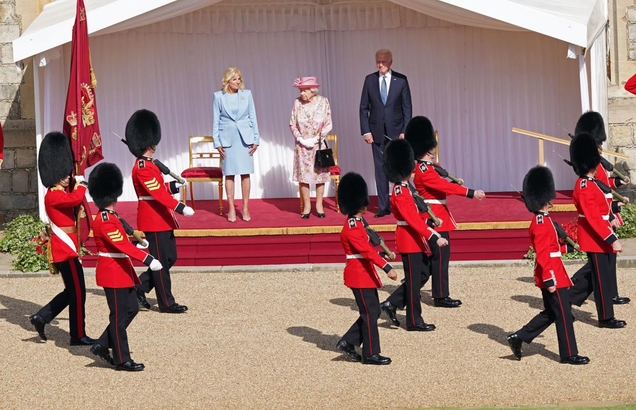 US President Joe Biden (R) and US First Lady Jill Biden (L) stand beside Britain's Queen Elizabeth II (C) to watch the military march past at Windsor Castle in Windsor, west of London, on June 13, 2021. - US president Biden will visit Windsor Castle late Sunday, where he and First Lady Jill Biden will take tea with the queen. (Photo by Arthur Edwards / POOL / AFP) (Photo by ARTHUR EDWARDS/POOL/AFP via Getty Images)