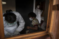 In this photo taken Friday, April 3, 2020 medical workers prepare to test a person, centre, for COVID-19 in a mobile testing unit in Yeoville, Johannesburg's. South Africa, one of the world's most unequal countries with a large population vulnerable to the new coronavirus, may have an advantage in the coronavrius outbreak, honed during years battling HIV and tuberculosis: the know-how and infrastructure to conduct mass testing. (AP Photo/Shiraaz Mohamed)