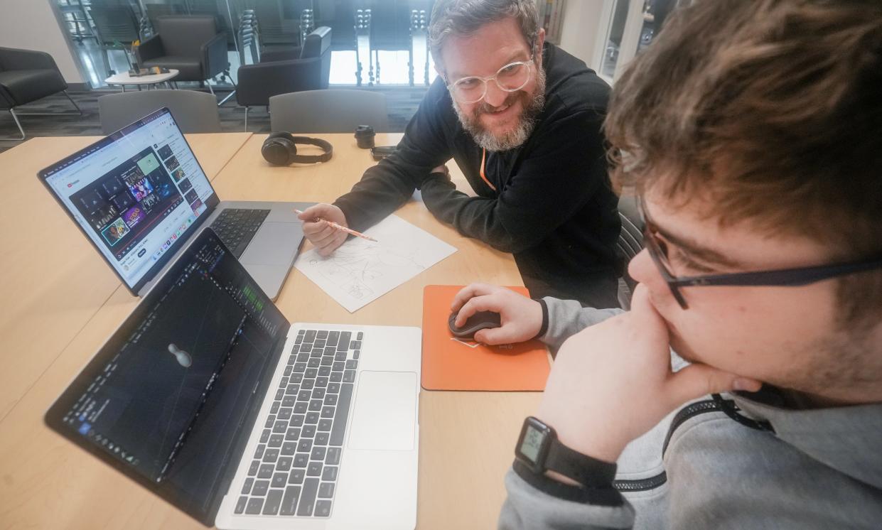 Chris Willey, director of technology at Islands of Brilliance, works with an autistic student to create a project focused on the student's special area of interest, bowling.