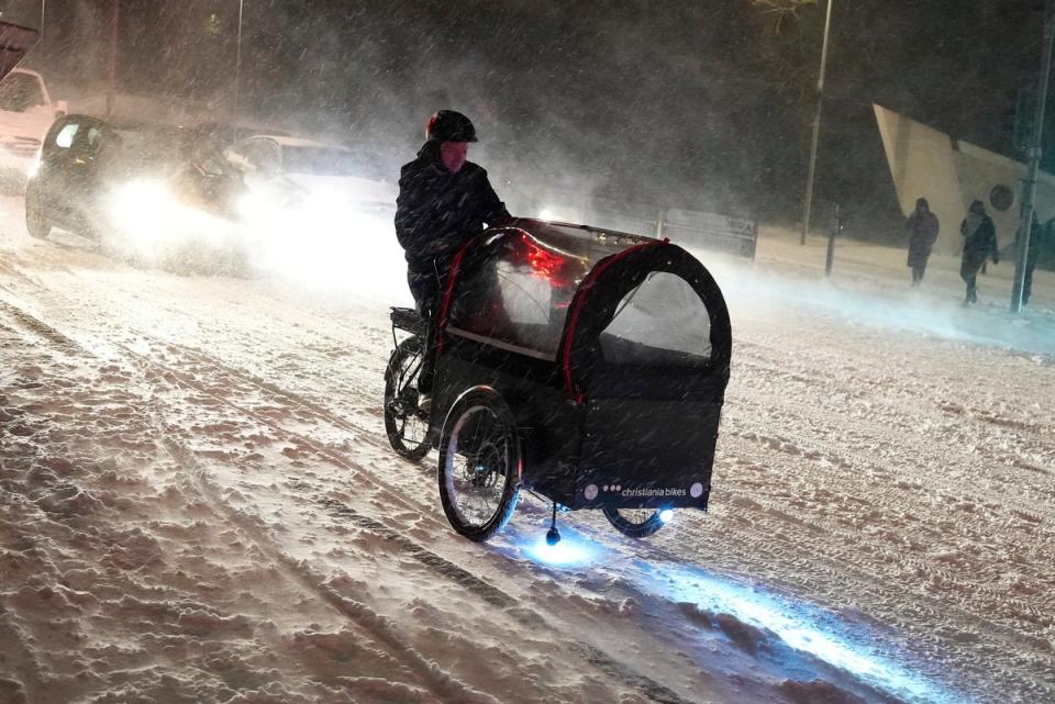 A person rides their bicycle as a blizzard hits the morning traffic in Aalborg, Denmark (EPA)