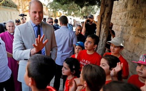 Prince William talks to Palestinian children during a visit to Jerusalem's Old City  - Credit: MENAHEM KAHANA /AFP