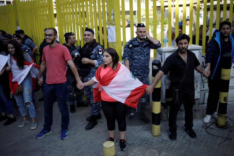 Demonstrators stand blocking access to the state owned electricity company during ongoing anti-government protests in Beirut