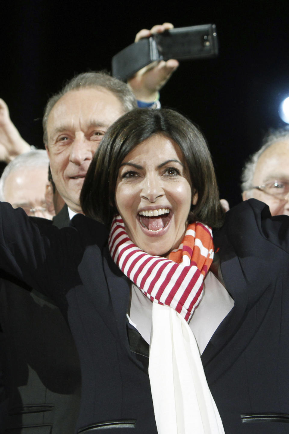 French Socialist Party deputy mayor of Paris, Anne Hidalgo smiles as outgoing mayor Bertrand Delanoe, stands behind her, during a speech after results were announced in the second round of the French municipal elections, in Paris, Sunday, March 30, 2014. Hidalgo saved Paris for the flagging Socialist Party in Sunday's municipal elections, becoming the French capital's first female mayor. (AP Photo/Thibault Camus)