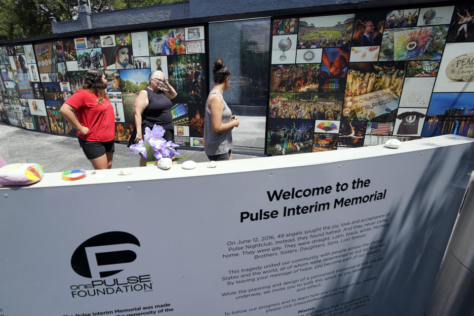 Visitors pay tribute to the display outside the Pulse nightclub memorial Friday, June 11, 2021, in Orlando, Fla. Saturday will mark the fifth anniversary of the mass shooting at the site. (AP Photo/John Raoux)