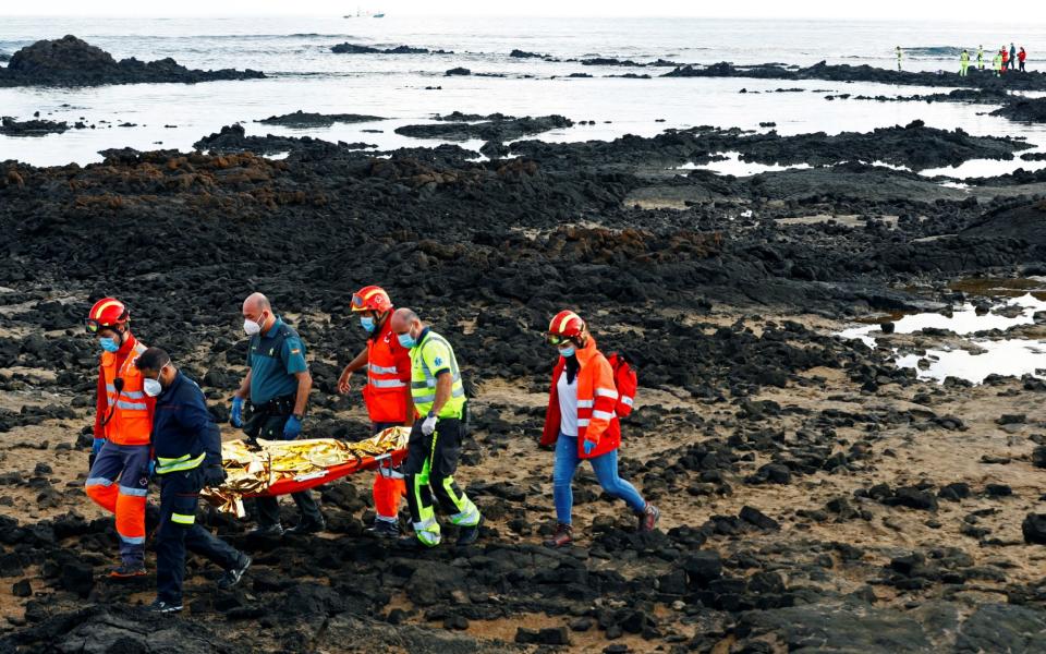 Rescue workers carry the body of a dead person