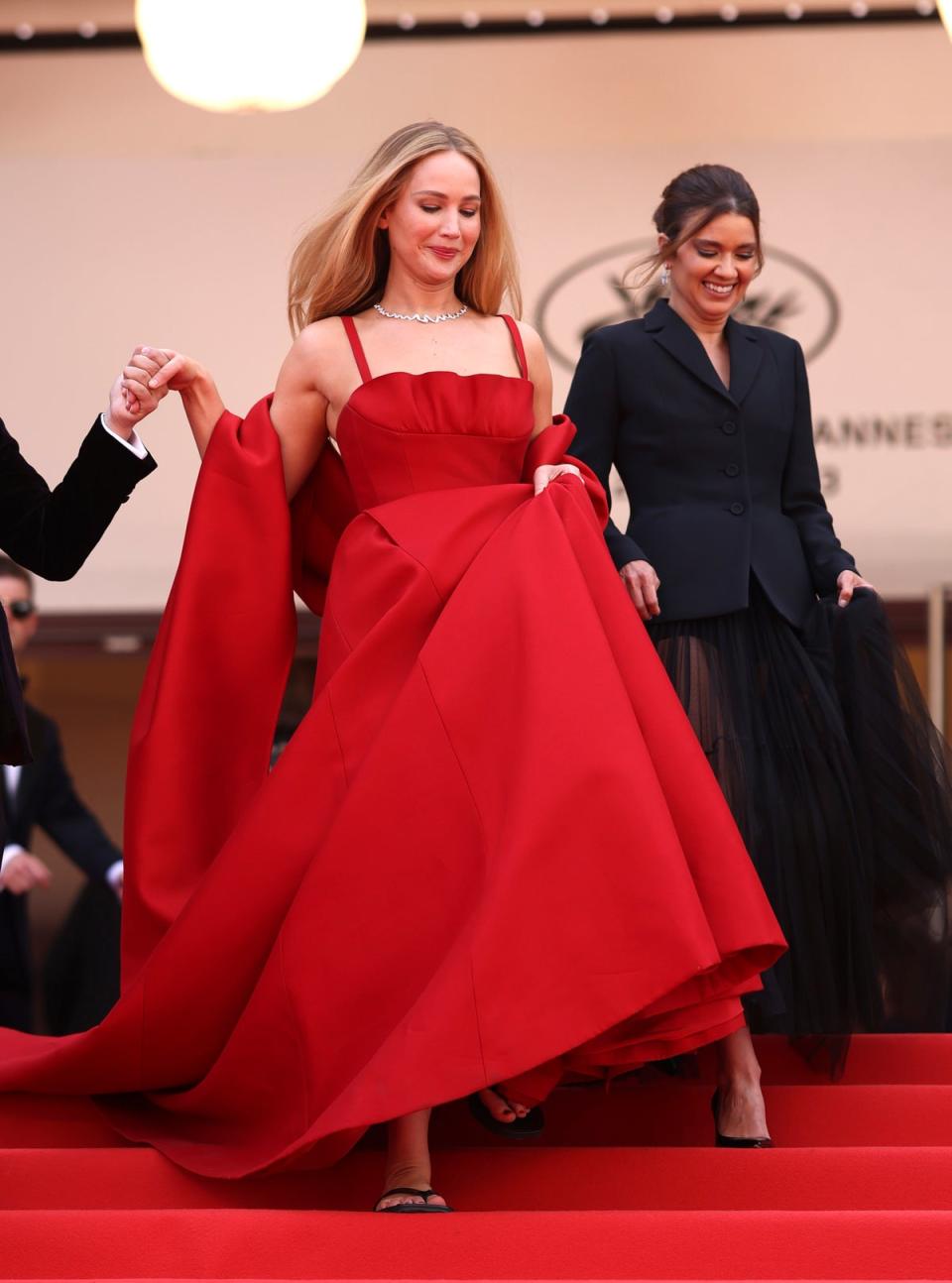 Jennifer Lawrence wears black flip-flops while descending steps at Cannes Film Festival red carpet (Vianney Le Caer/Invision/AP)