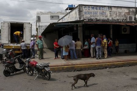 People line up as they wait for the arrival of basic goods outside a grocery store, in Sabaneta, in the state of Barinas, November 19, 2015. REUTERS/Marco Bello.