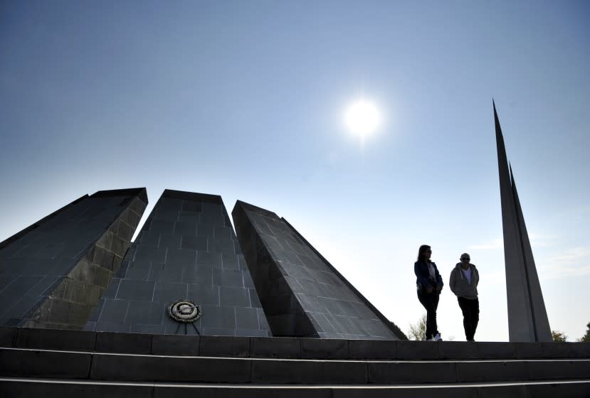 A couple walk at the Tzitzernakaberd memorial to the victims of mass killings by Ottoman Turks, in the Armenian capital Yerevan, Armenia, Wednesday, Oct. 30, 2019. The U.S. House of representatives has voted overwhelmingly to recognize the century-old mass killings of Armenians by Ottoman Turks as genocide. The move is a clear rebuke to NATO ally Turkey in the wake of its invasion of northern Syria. (AP Photo/Hakob Berberyan)