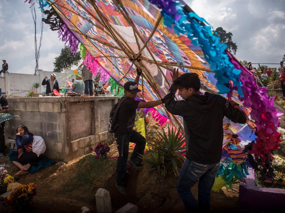 Youths try to make their kite fly at the cemetery on All Saints Day in Santiago Sacatepequez, Guatemala, Thursday, Nov. 1, 2018, as part of Day of the Dead celebrations. According to tradition, kites help keep bad spirits away as the souls of the dearly departed return overnight for Day of the Dead.