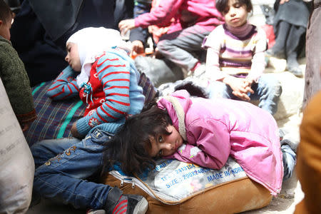 A girl looks at the camera during evacuations from the besieged town of Douma, Eastern Ghouta, in Damascus, Syria March 22, 2018. REUTERS/Bassam Khabieh