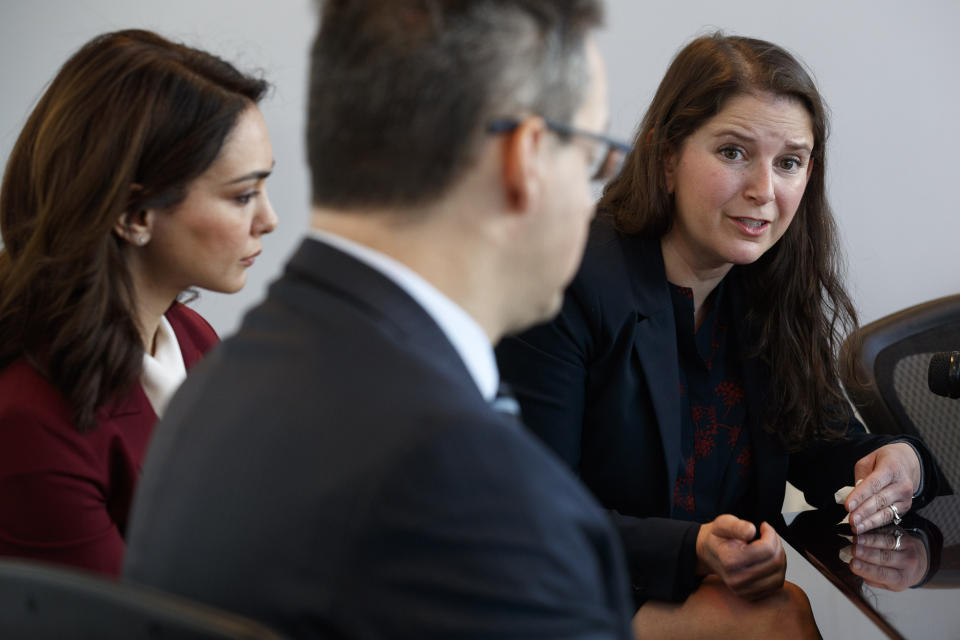 Nazanin Boniadi, left, an actress and activist, listens as Sarah Moriarty, the daughter of Robert Levinson, a U.S. hostage in Iran, speak about her father's captivity, Tuesday, Dec. 3, 2019, in Washington. At front is international human rights lawyer Jared Genser. (AP Photo/Jacquelyn Martin)