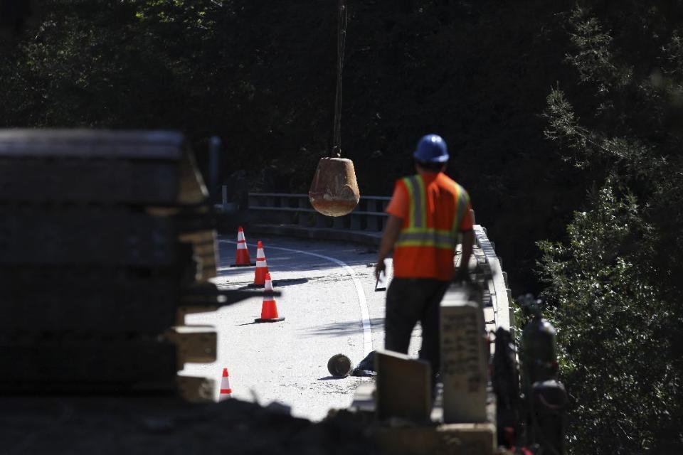 Construction crews use a wrecking ball to dismantle the Pfeiffer Canyon Bridge on Highway 1 Monday, March 13, 2017, in Big Sur, Calif. The bridge was compromised after slides occurred in the area associated with this winter's heavy rains. (AP Photo/Nic Coury)