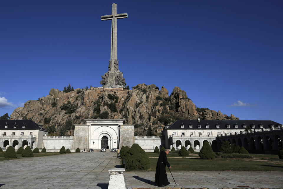 A monk walks in front of The Valley of the Fallen mausoleum near El Escorial, outskirts of Madrid, Spain, Sunday, Oct. 13, 2019. After a tortuous judicial and public relations battle, Spain's Socialist government has announced that Gen. Francisco Franco's embalmed body will be relocated from a controversial shrine to a small public cemetery where the former dictator's remains will lie along his deceased wife. (AP Photo/Manu Fernandez)