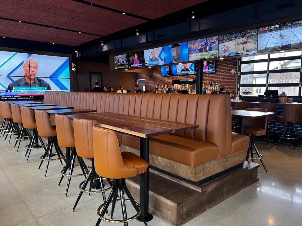 The center banquette of seating at Bix & Co. is elevated with stools on the opposite side.