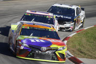 Kyle Busch (18), Denny Hamlin (11) and Aric Almirola (10) compete in the NASCAR Cup Series race at Martinsville Speedway in Martinsville, Va., Sunday, Oct. 27, 2019. (AP Photo/Steve Helber)