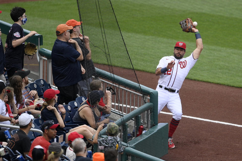 Washington Nationals left fielder Kyle Schwarber (12) can't catch a foul ball hit by San Francisco Giants' Steven Duggar in foul territory during the eighth inning of a baseball game, Sunday, June 13, 2021, in Washington. The Nationals won 5-0.(AP Photo/Nick Wass)