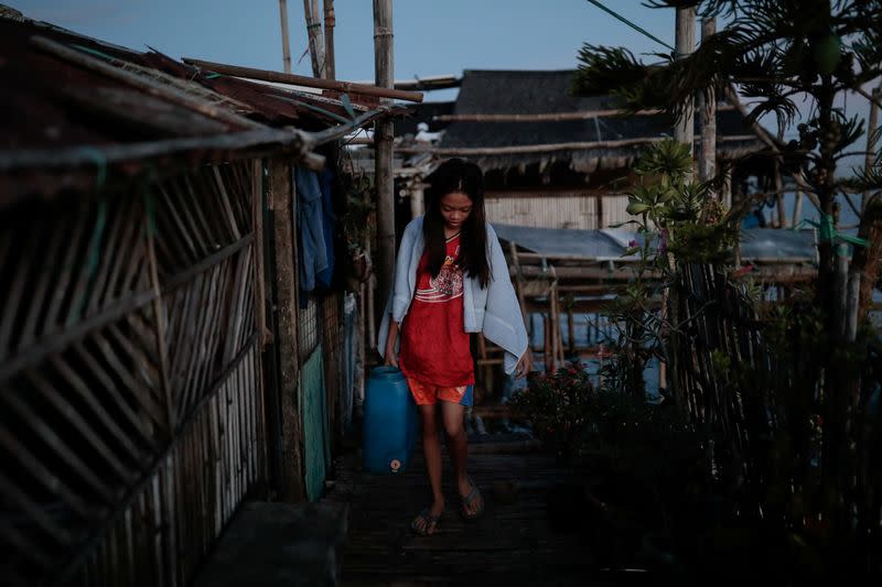 The Wider Image: Rising seas threaten early end for sinking village in Philippines