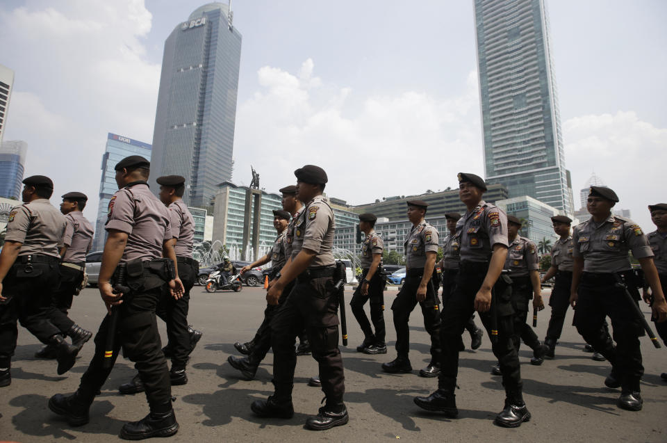 Indonesian police walk in Jakarta, Indonesia, Tuesday, May 21, 2019. Indonesia's President Joko Widodo has been elected for a second term, official results showed Tuesday, in a victory over a would-be strongman who aligned himself with Islamic hardliners. Thousands of police and soldiers are on high alert in the capital Jakarta, anticipating protests from Widodo's challenger Prabowo Subianto's supporters. (AP Photo/Achmad Ibrahim)