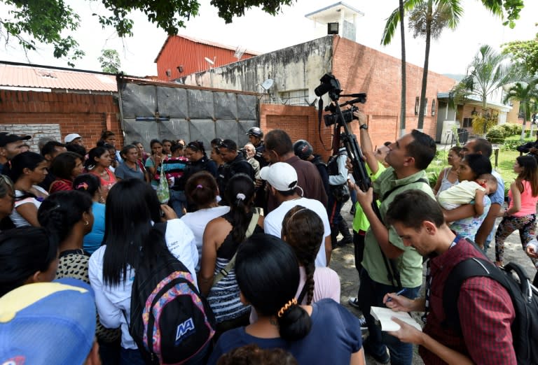 Police give information to anxious relatives of prisoners outside a jail in Venezuela where a deadly fire took place