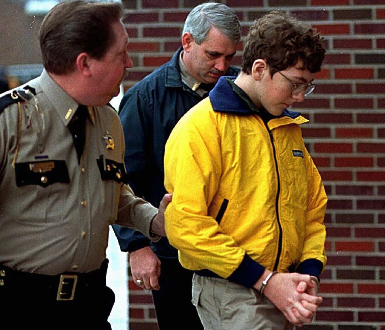 FILE - Heath High School shooting suspect Michael Carneal is escorted out of the McCracken County Courthouse after his arraignment in Paducah, Ky., Jan. 15, 1998. 