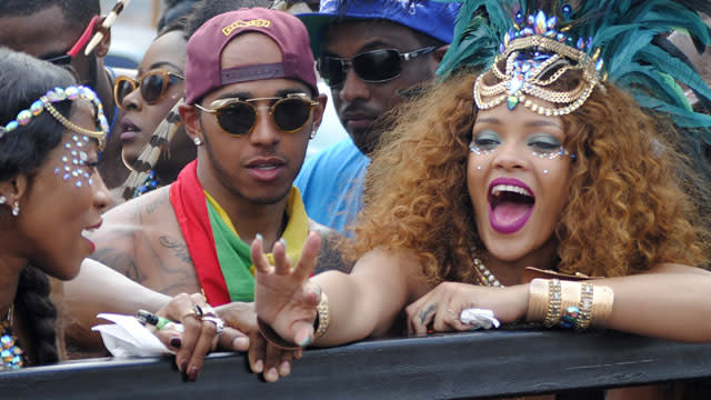 Rihanna was once again back in Barbados for the annual Crop Over festivities, and this time, she had a famous friend in her squad. The 27-year-old singer was spotted partying and dancing with Nicole Scherzinger's ex-fiance, Lewis Hamilton, at the Crop Over's Kadooment Day Parade. The 30-year-old shirtless British race car driver celebrated wearing a backwards hat, trendy sunglasses and a colorful bandanna around his neck. Both his Calvin Klein underwear and his rock-hard abs were in full view. Splash News The hat was apparently covering up his new 'do. "Barbados, we ready!! #Islandlife #Carnival2015," Hamilton captioned a selfie of his hair. While recent pics of Rihanna and Hamilton partying are sparking romance rumors, the two known each other for a few years. In Dec. 2014, the two posed together at the British Fashion Awards in London, and in 2011, they were also photographed at the Canadian Grand Prix. <strong> WATCH: Rihanna Taped Floyd Mayweather's Mouth Shut at BET Awards </strong> While Hamilton was a nice addition to the party, all eyes were on Rihanna and her show-stopping costume on Monday. Like those Crop Over styles from years past, the intricately beaded getup included a barely-there bra and booty-baring bikini bottoms. Rihanna paired her sexy style with a huge headdress and giant wings. The outlandish pop star knew she looked good because she couldn't stop Instagramming during the festivities on Monday. She even posted a video of her booty shaking that's nearly NSFW. <strong> PHOTOS: Nearly Naked Rihanna Takes Over Kadooment Day Parade With Best Costume Yet </strong> One thing's for sure, RiRi knows how to party and so does her best gal pal Jennifer Rosales, who was also in attendance. <strong> PHOTOS: Rihanna Might Just Be the Best Bridesmaid Ever </strong> Hamilton is one lucky guy to be partying with these gals! Squad goals, indeed. 